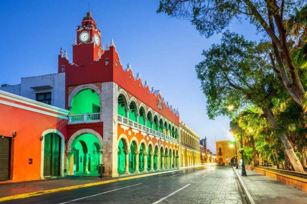 big building with many color lights next to a park