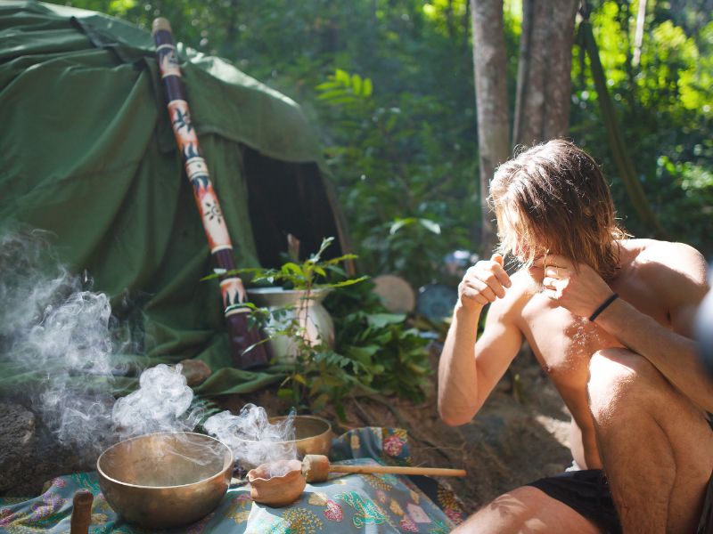 Persona en un ritual de temazcal, con baño de vapor, hiervas, agua y comida propias del ritual